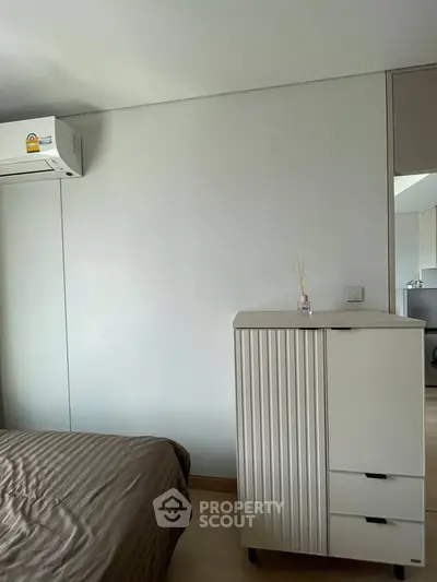 Modern bedroom with air conditioning and sleek storage unit, perfect for minimalist living.