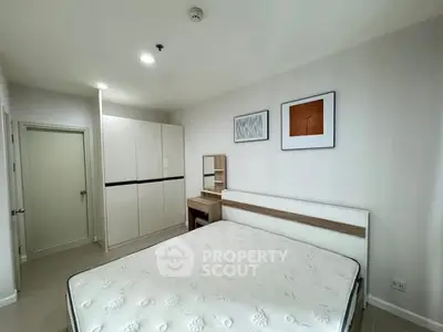 Modern bedroom with minimalist design, featuring a comfortable bed and stylish furniture.