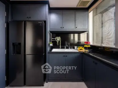 Modern kitchen with sleek black cabinetry and stainless steel appliances