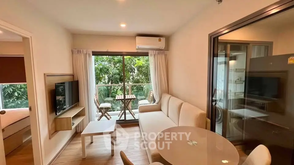 Modern living room with balcony view, featuring cozy seating and natural light.