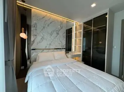 Luxurious modern bedroom with marble accent wall and sleek lighting