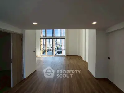 Spacious modern living room with high ceilings and large windows offering abundant natural light.