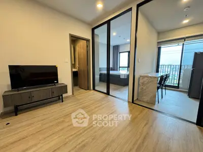 Modern apartment interior with open layout, featuring a cozy living area and a stylish kitchen with balcony access.
