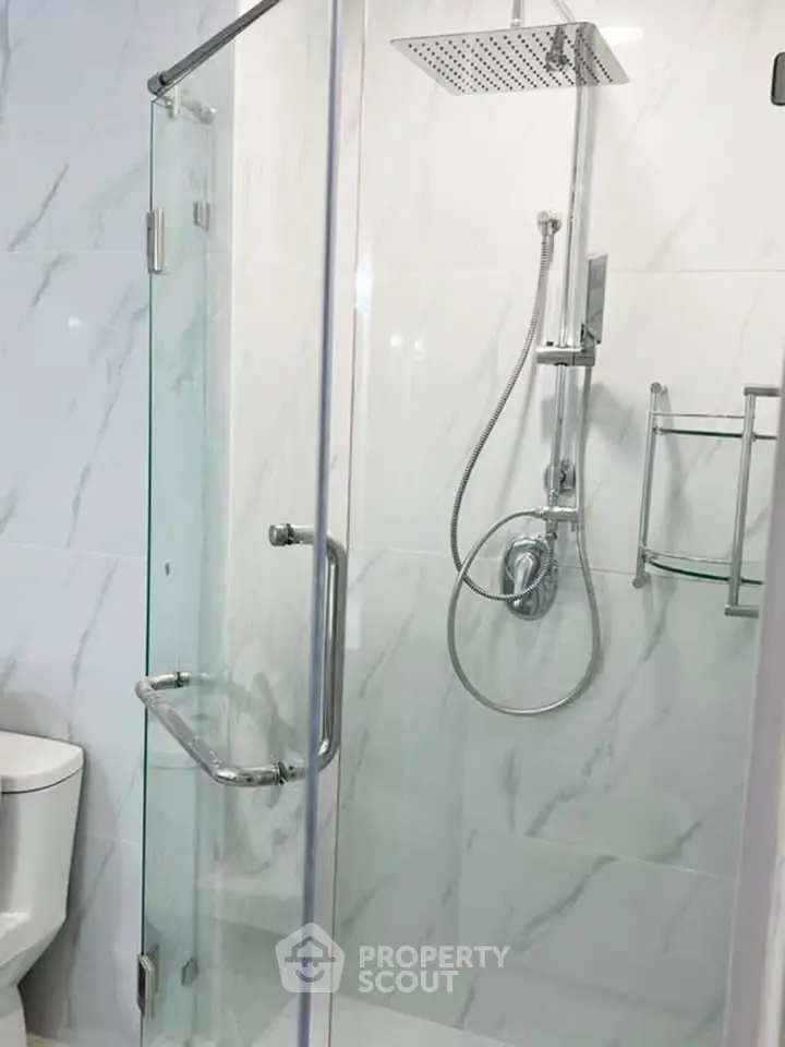 Modern bathroom with glass shower enclosure and sleek fixtures