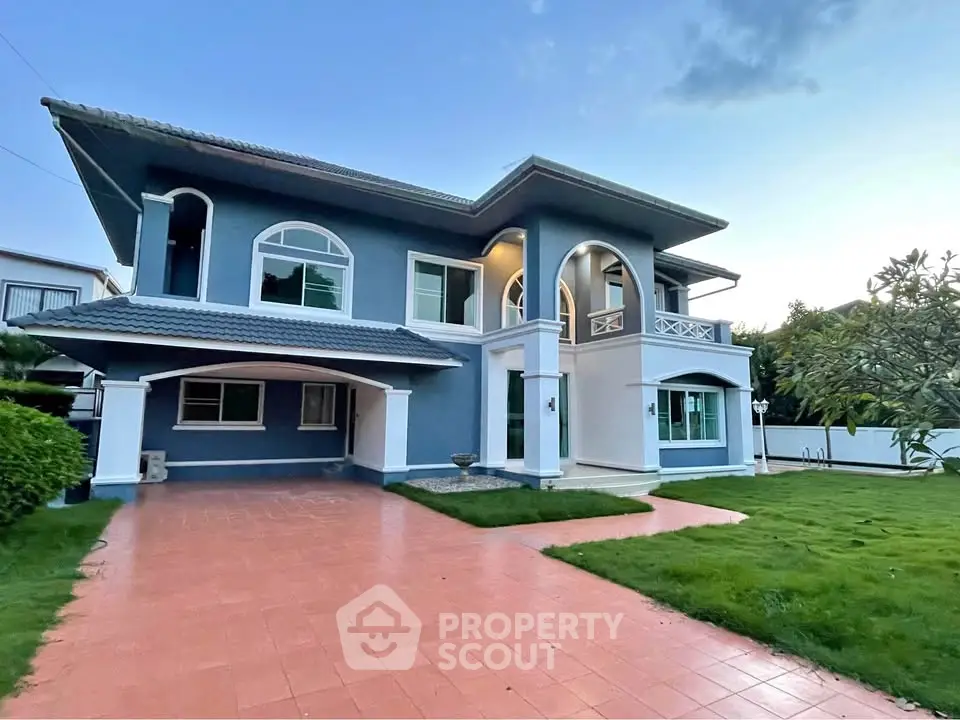 Stunning two-story blue house with spacious driveway and lush green lawn