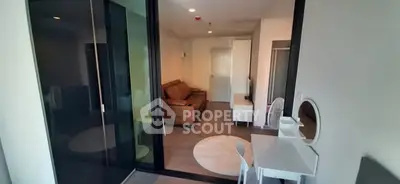 Modern living room with sleek furniture and glass partition in a stylish apartment.