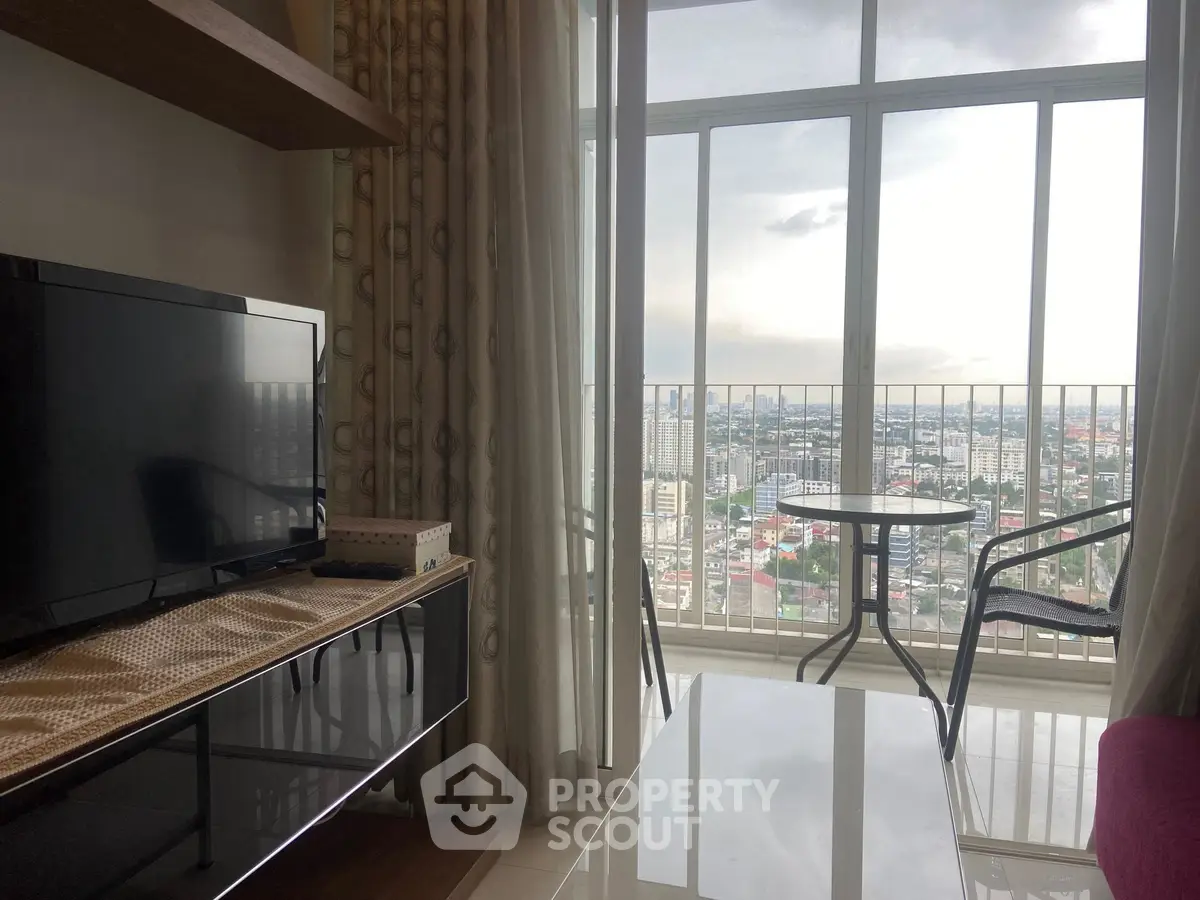 Stylish living room with floor-to-ceiling windows offering stunning city views, modern furniture, and cozy ambiance.