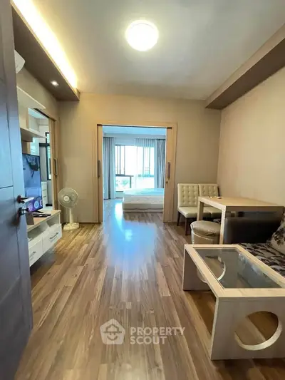 Modern open-plan living room with wooden flooring and cozy furniture