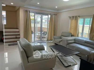 Spacious modern living room with elegant leather sofas and large windows for natural light.