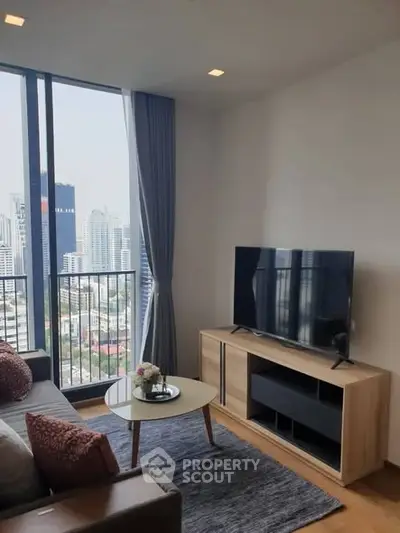 Modern living room with city view, featuring sleek furniture and large windows for natural light.