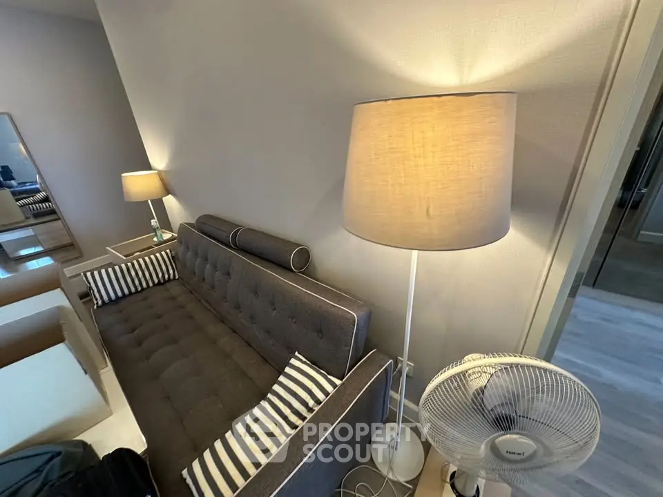 Cozy living room with stylish sofa and modern floor lamp, perfect for relaxation.