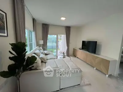 Spacious modern living room with elegant decor and large windows for natural light.