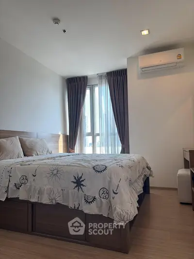 Modern bedroom with stylish decor and natural light in a high-rise apartment.
