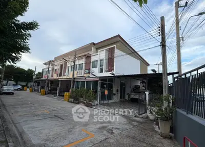 Modern townhouse exterior with parking space and lush greenery in a serene neighborhood.