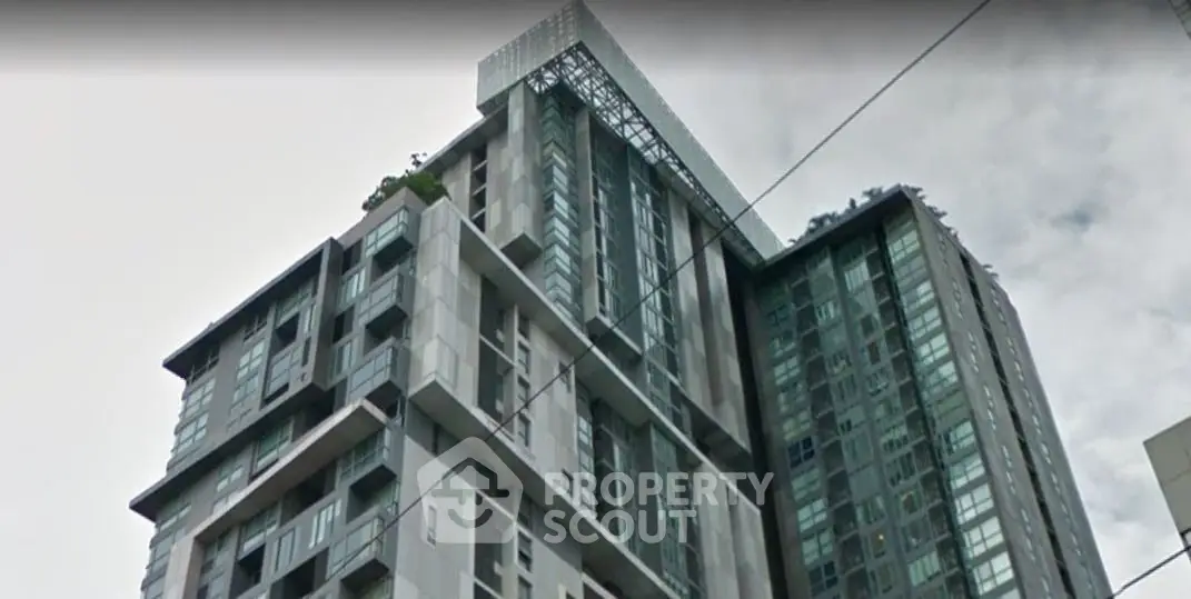 Modern high-rise building with sleek architecture and glass facade in urban setting.