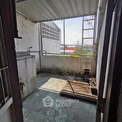 Spacious outdoor balcony with partial roof and city view, ideal for urban living.