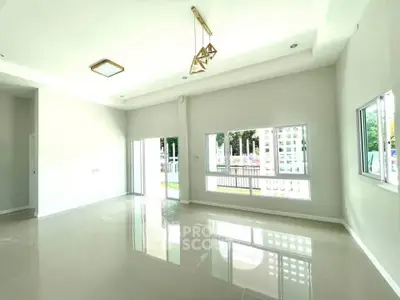 Spacious modern living room with large windows and elegant lighting