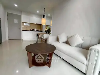 Modern living room with cozy sofa and stylish coffee table in open-plan apartment.