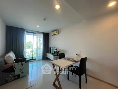 Modern living room with balcony view, sleek furniture, and abundant natural light in a stylish apartment.