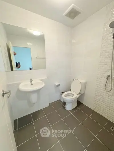 Modern bathroom with sleek white tiles and walk-in shower