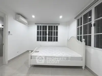 Spacious bedroom with large windows and air conditioning in modern apartment
