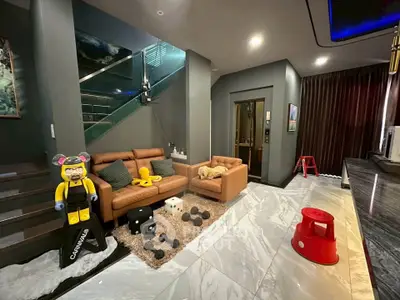 Modern living room with stylish decor and unique art pieces, featuring a cozy seating area and sleek marble flooring.