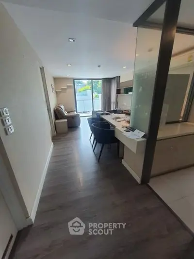 Modern open-layout living room with dining area and large windows for natural light.
