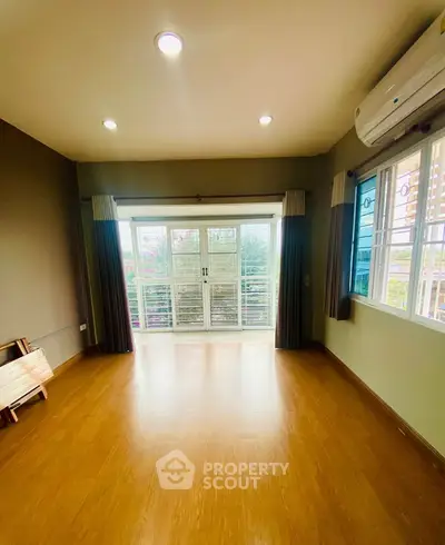 Spacious room with large windows and balcony access, perfect for natural light lovers.