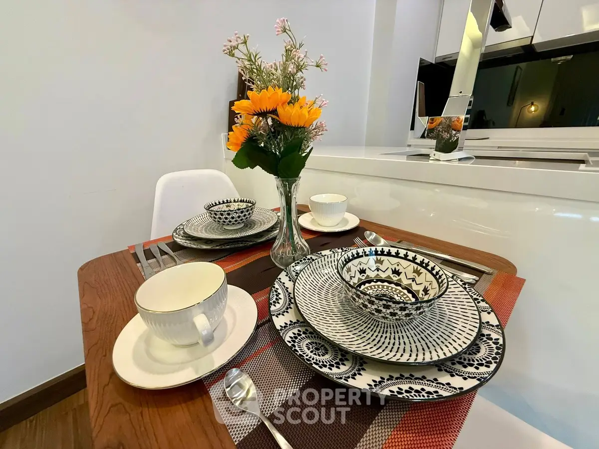 Stylish dining setup in modern kitchen with elegant tableware and floral centerpiece.