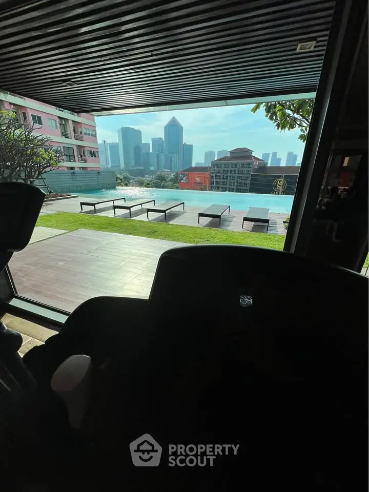 Luxurious rooftop pool with stunning city skyline view and modern sun loungers.