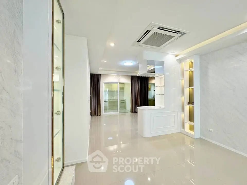 Spacious modern living room with elegant built-in shelves and sleek ceiling design.