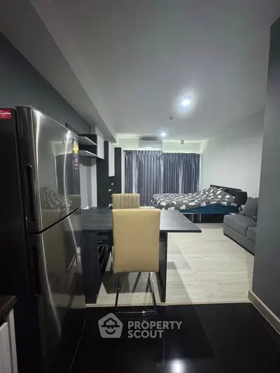 Modern studio apartment with sleek kitchen and cozy living area, featuring stylish furnishings and ample natural light.