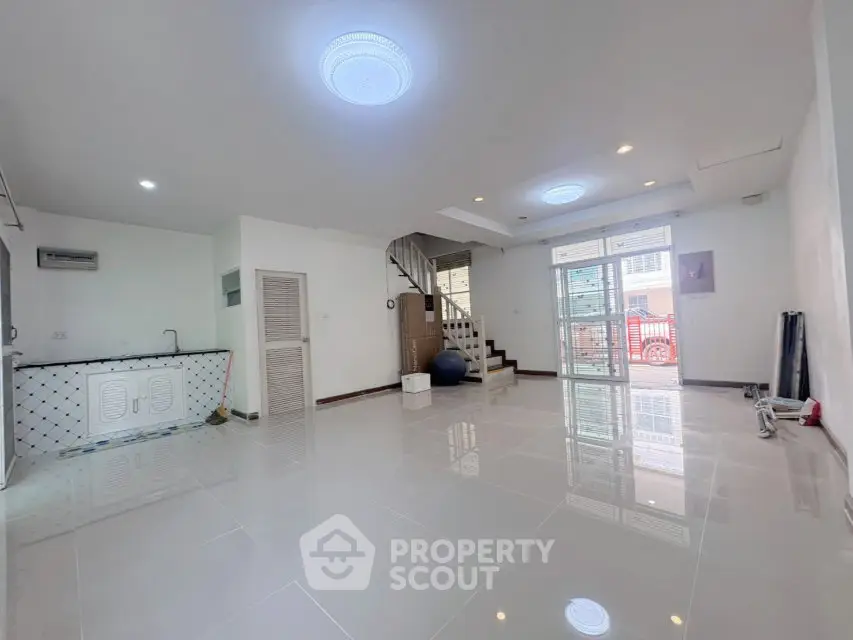 Spacious modern living room with sleek tile flooring and abundant natural light.