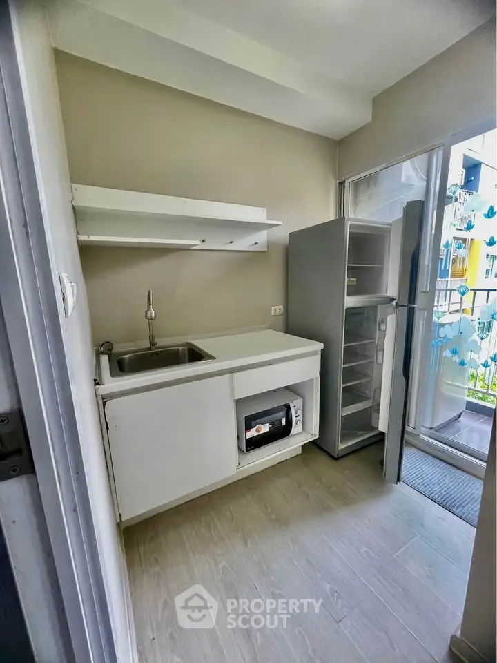 Compact kitchen with fridge and microwave, ideal for small apartments