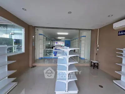 Spacious commercial space with shelving and glass partitions, ideal for retail or office use.