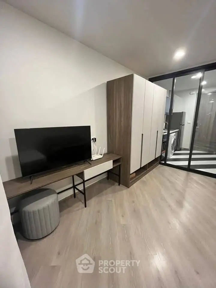 Modern living room with sleek TV stand and spacious wardrobe in stylish apartment.