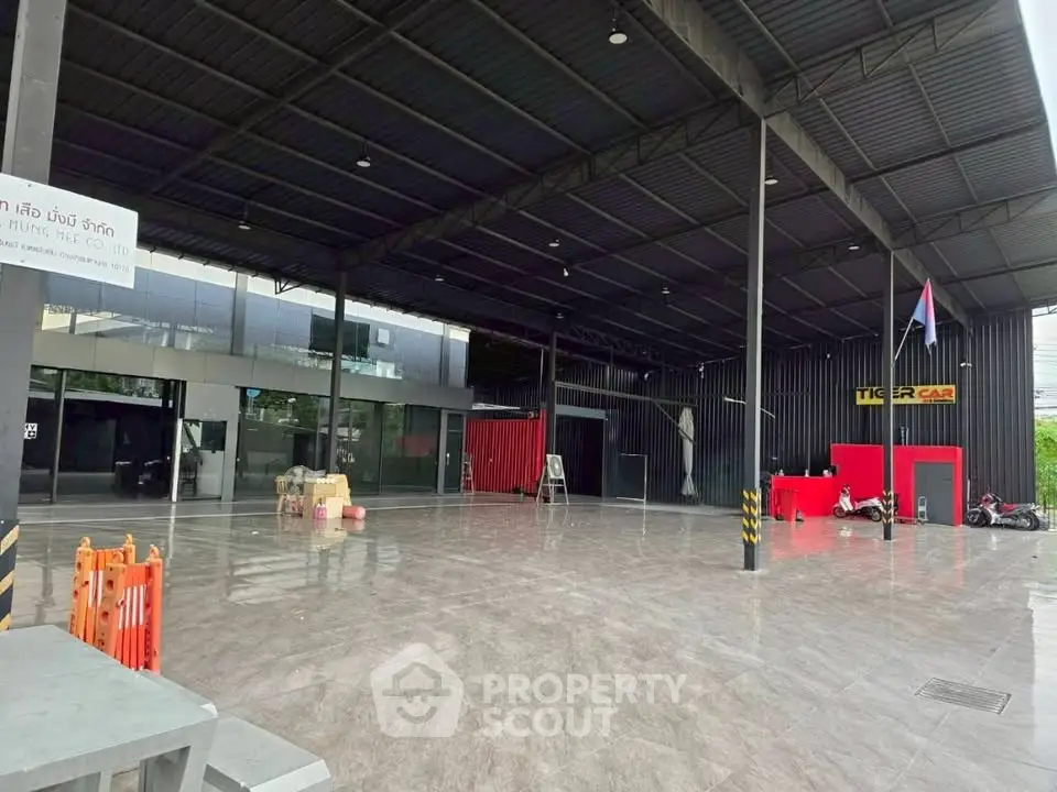 Spacious commercial property with modern industrial design and ample parking space.