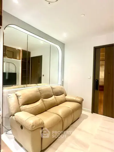 Modern living room with beige leather sofa and mirrored wall accent