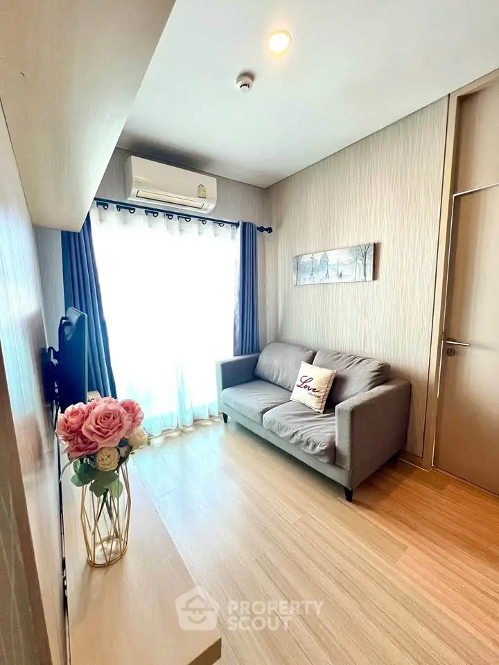 Cozy living room with modern decor and natural light, featuring a comfortable sofa and stylish flooring.