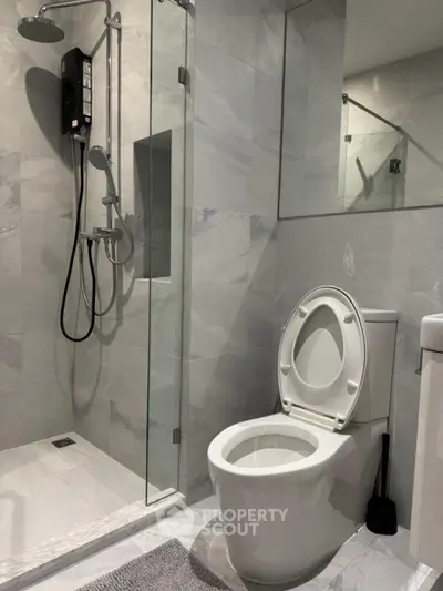 Modern bathroom with sleek shower and toilet in contemporary design.