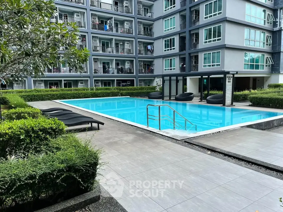 Modern apartment complex with inviting swimming pool and lush greenery.