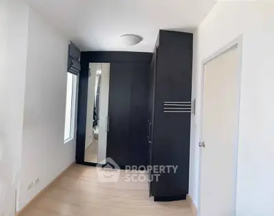 Spacious bedroom with sleek black wardrobe and modern design