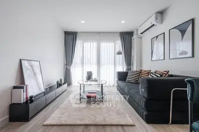 Modern living room with sleek furniture and large windows for natural light.