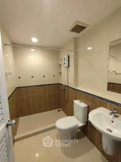 Modern bathroom with sleek fixtures and spacious shower area.