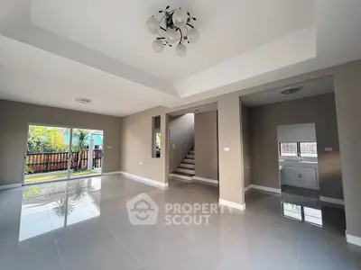 Spacious modern living room with large windows and glossy tile flooring