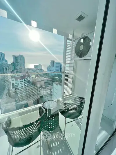 Stunning high-rise balcony with panoramic city and ocean views, perfect for relaxation.