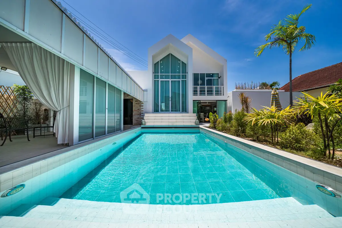 Luxurious modern villa with stunning pool and lush garden, perfect for relaxation and entertainment.