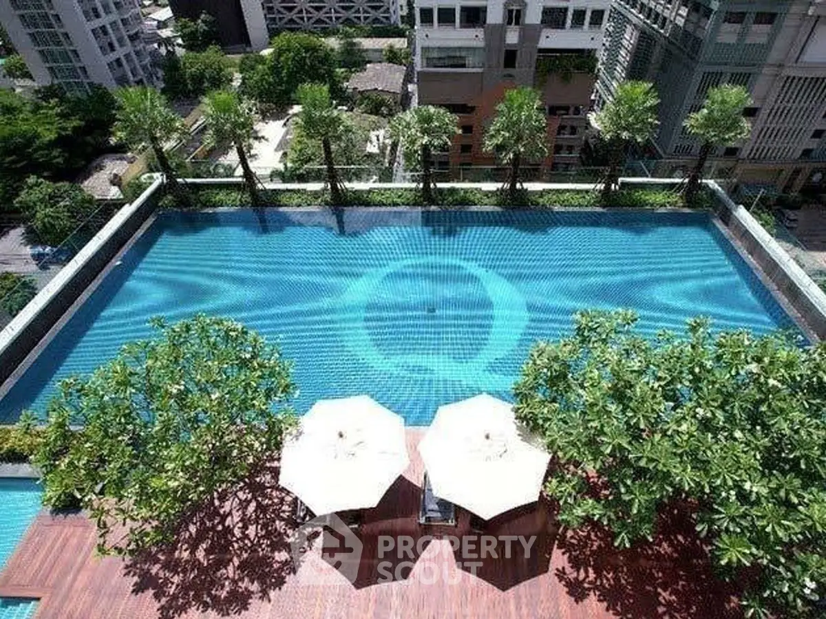 Luxurious rooftop pool with stunning city views and lush greenery, perfect for relaxation and leisure.