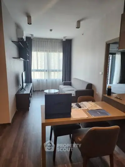 Modern living room with sleek furniture and large window, perfect for urban living.