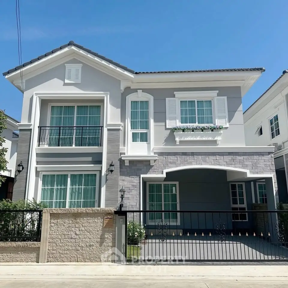 Elegant two-story house with modern facade and spacious driveway in a serene neighborhood.